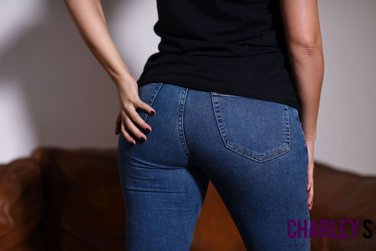 Brunette modèle Charlotte springer découvre Nu seins Alors que peeling Jeans off