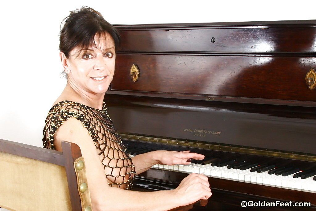 Idade maduro mulher senhora Sarah jogar Piano no ver através de malha roupa