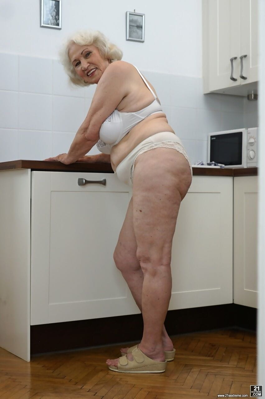 Freaky old blonde granny named Norma showing her tits in the kitchen