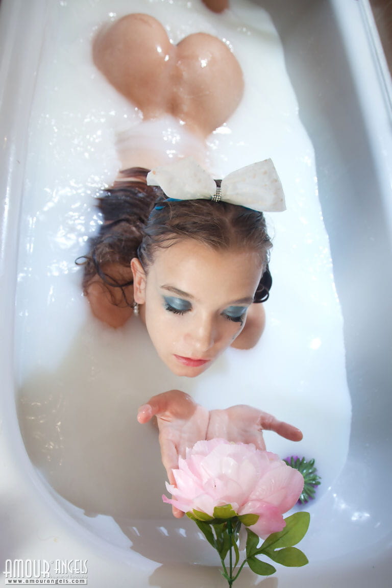 Tiny teen girl Alisabelle pours milk over her naked body while taking a bath