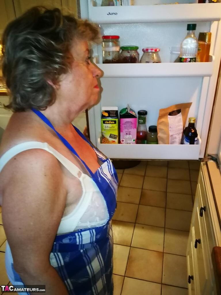 Eski ev hanımı Caro Alır kapalı onu iç çamaşırı içinde mutfak önlük ve çorap