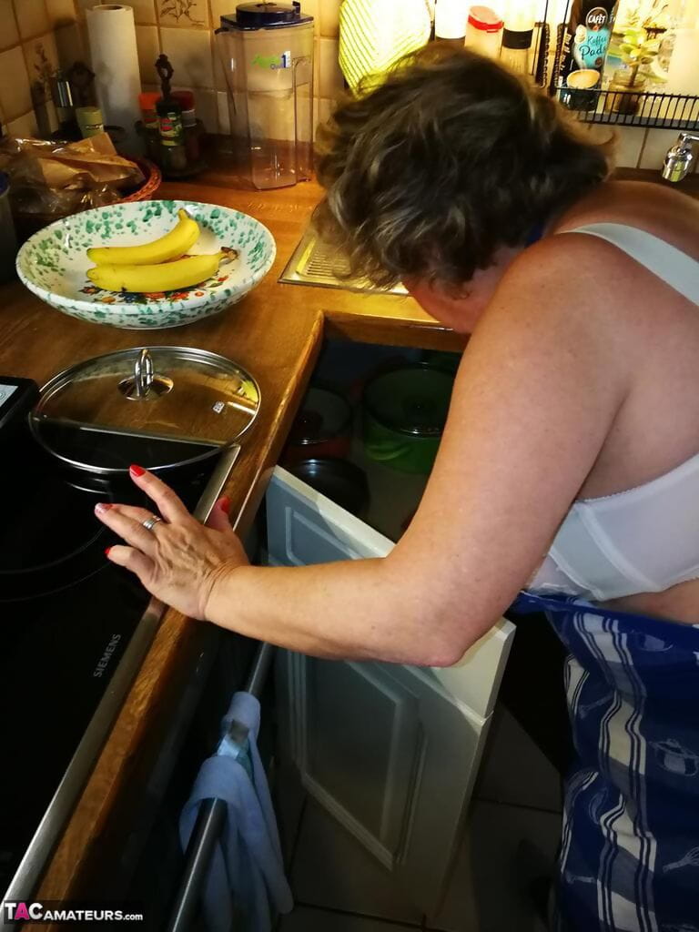 старый домохозяйка Каро берет офф ее нижнее белье в кухня фартук и чулки