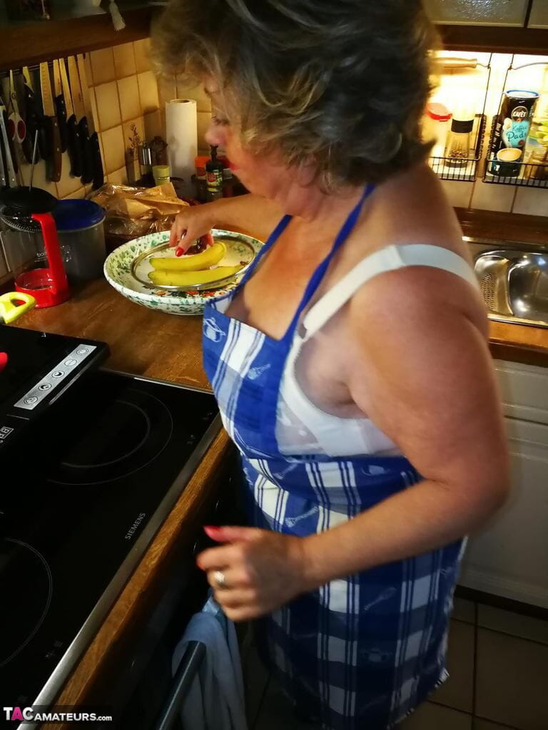 oud huisvrouw Caro neemt uit haar ondergoed in keuken schort en kousen