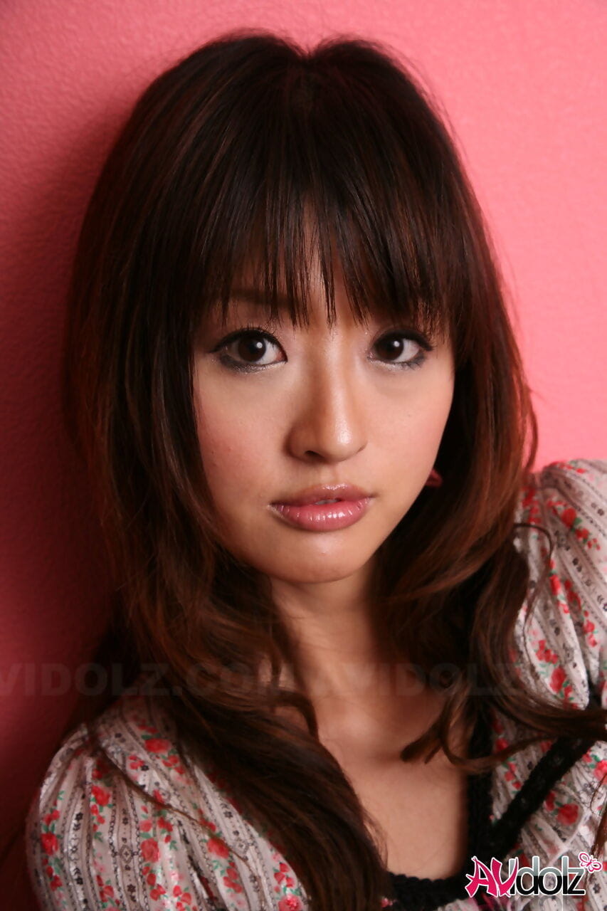 japonés modelo Con Un Bastante la cara stands Vestido en contra de Un rosa la pared
