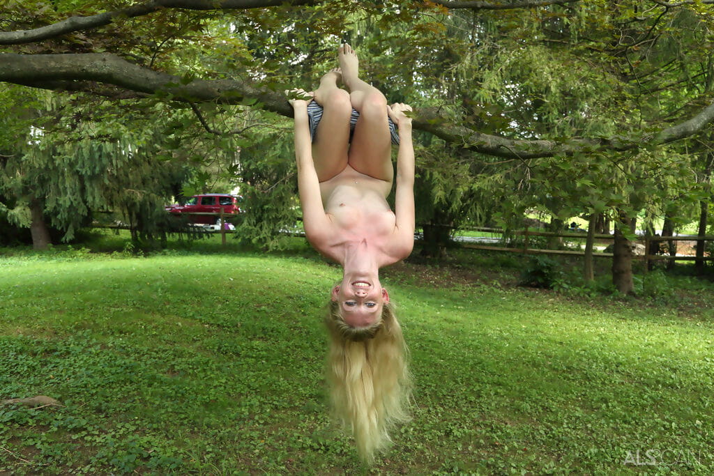 Cute blonde Emma Starletto shows off her flexibility while naked in the yard