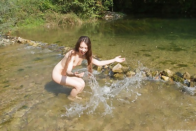 Teen girl with smiley face exposes her tiny tits and beaver in a stream